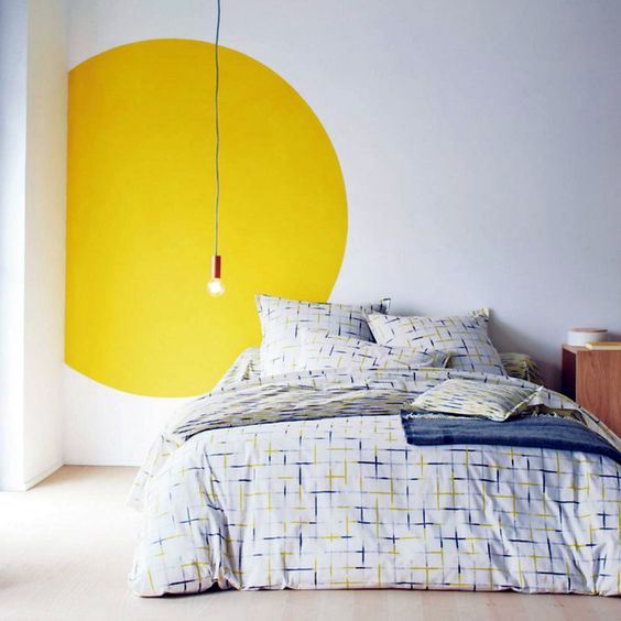 A yellow circle behind a simple light bulb creates a statement feature without expense