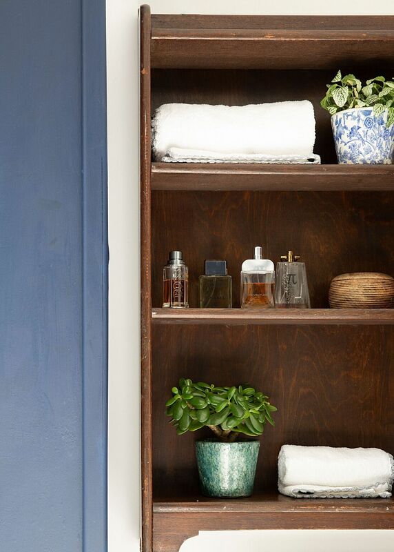Shelf styling in a bathroom with vintage shelving, modern cosmetics and accessories. 