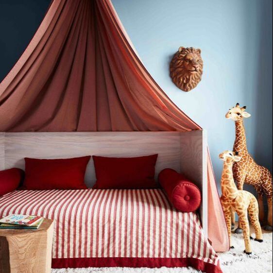 red and white childs bedroom with a red canopy