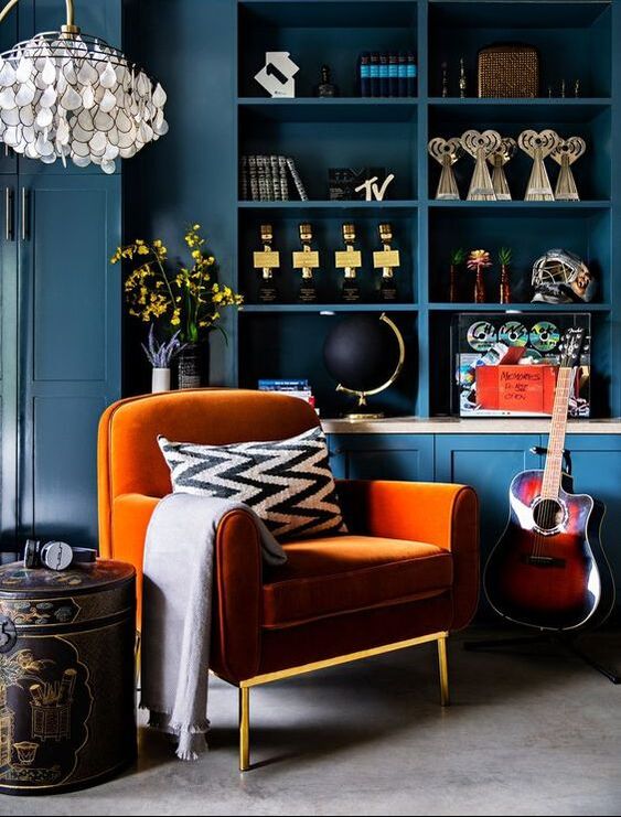 Orange velvet armchair in front of the dark blue cabinetry - by Peti Lau