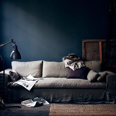 indigo walls and a pale beige sofa