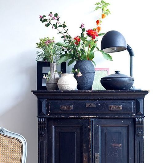 indigo cupboard with styled vases and flowers above