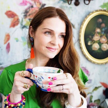 Ju De Paula in her colourful room drinking tea!