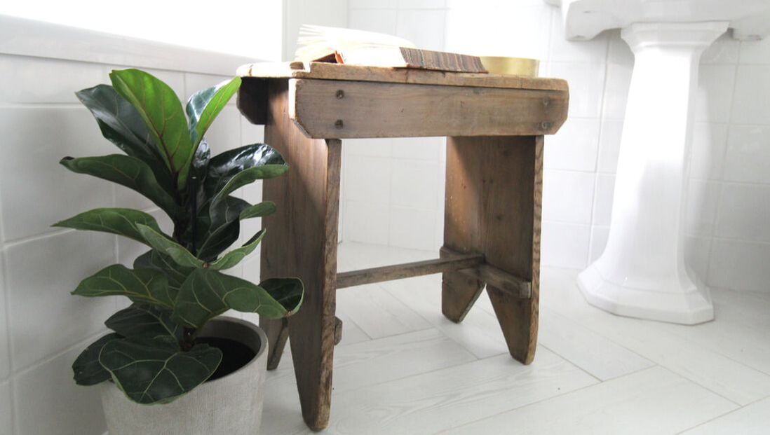 antique bench with an old book above it next to the bath
