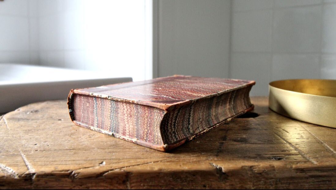 vignette of antique book on an old wooden bench