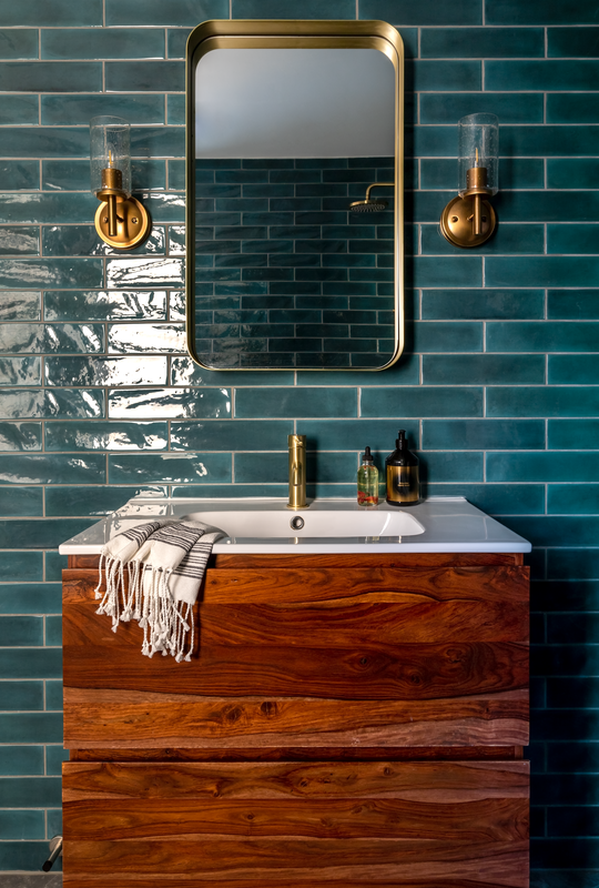 green and gold bathroom sink with wood vanity