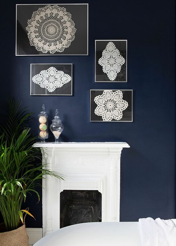 White victorian fireplace with indigo blue walls with framed crochet