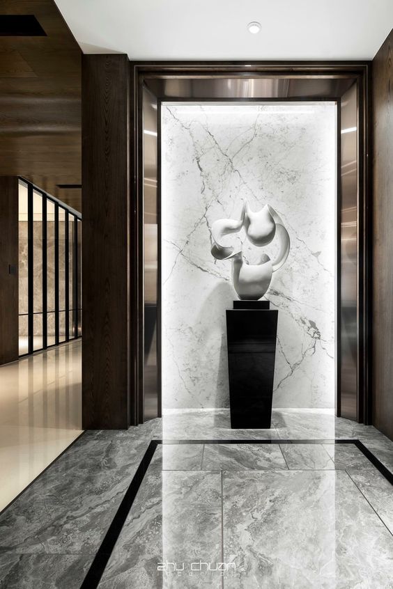 abstract organic form sculpture in a marble hallway