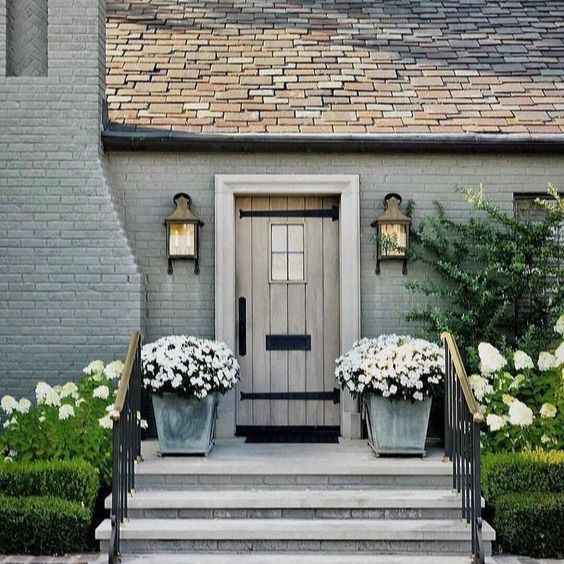 top 5 things to do after you move into your new home with a photo of a beautiful doorway flanked by white hydrangeeas