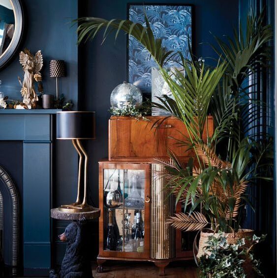 Indigo living room with styled vintage furniture and palms