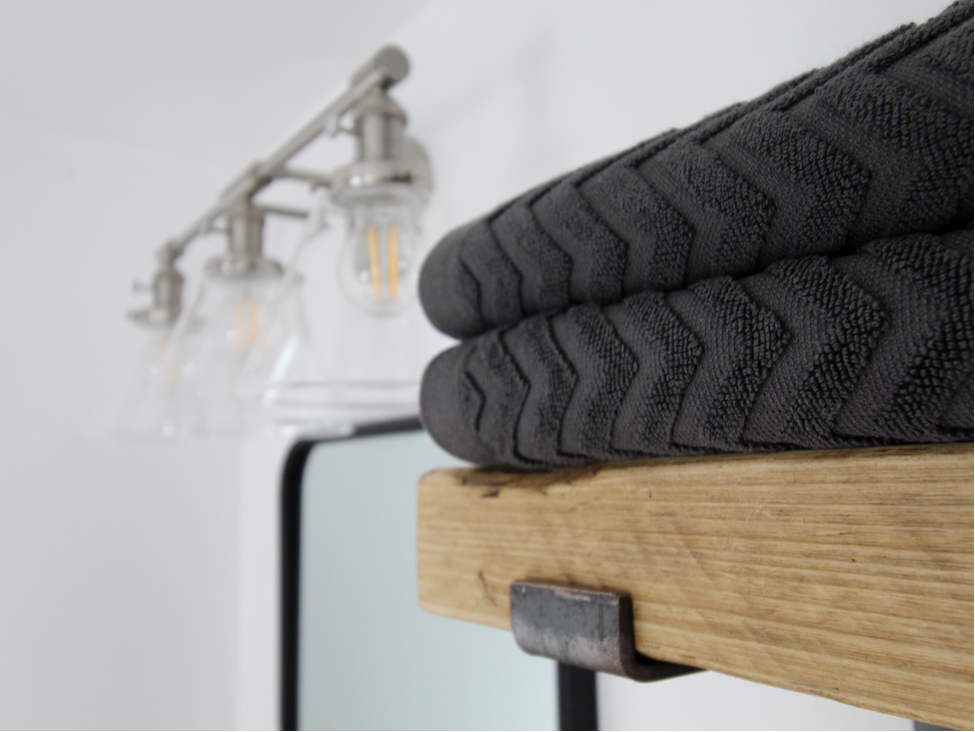 industrial lighting and shelving with black textured towels