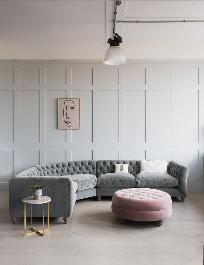 grey velvet button back l shaped sofa against grey panelling