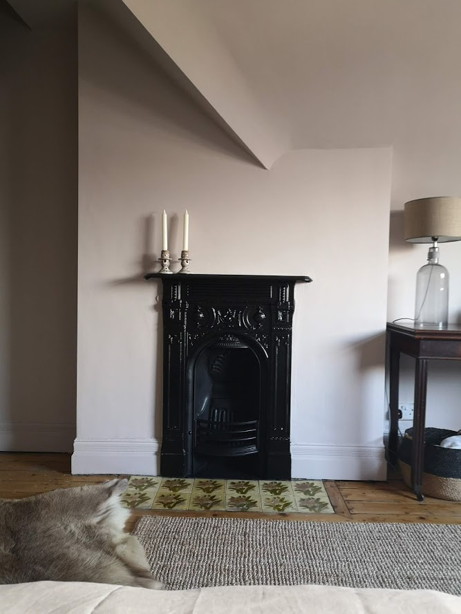 painting the skirting boards the same colour as the walls increases the sense of height. Contrasting fireplace in matt black adds drama and definition
