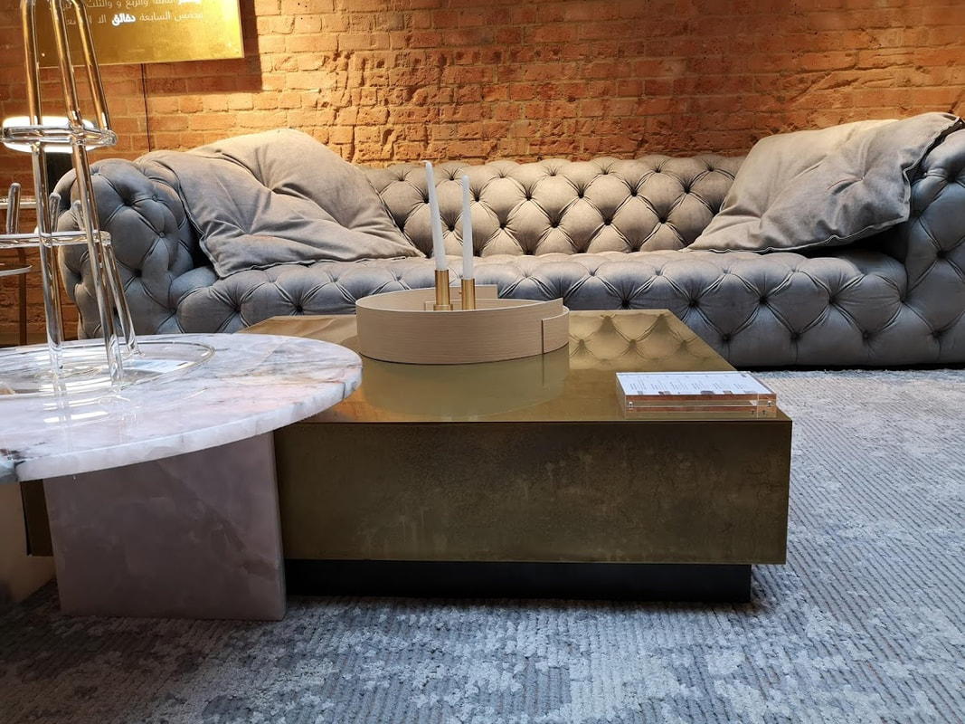 a multilayered coffee table, one in pink marble and one in polished brass