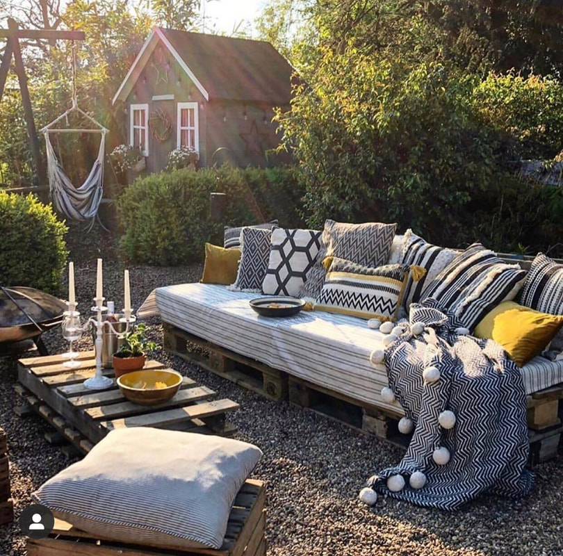 Outdoor sofa made from palettes. Monochrome and mustard tones with a firepit
