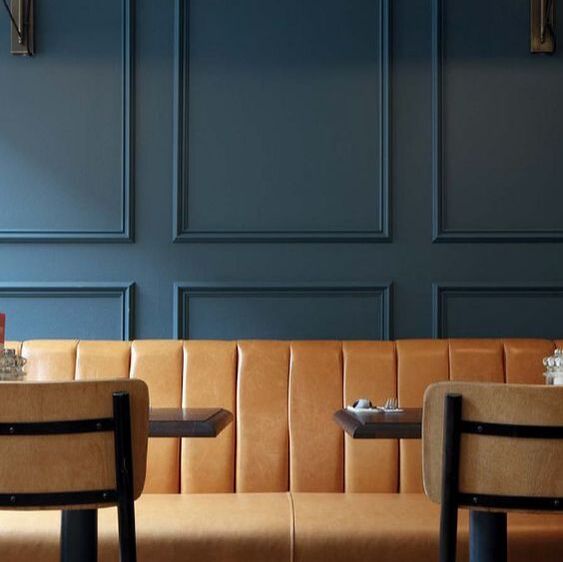 panelling in a bistro in dark blue with tan leather upholstery