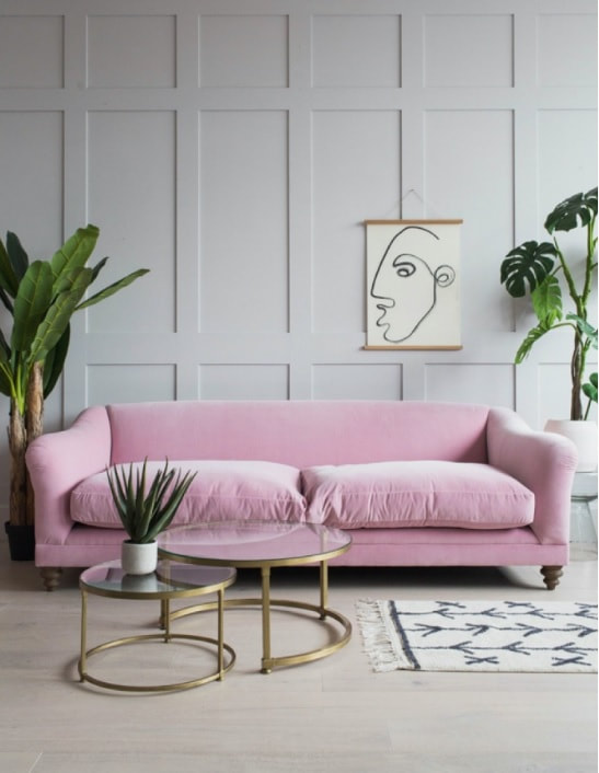 pink velvet sofa against grey panelling wall