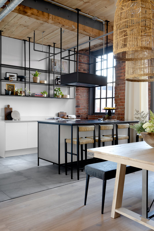modern kitchen with white and metal units, styled with antique wood accessories and plants